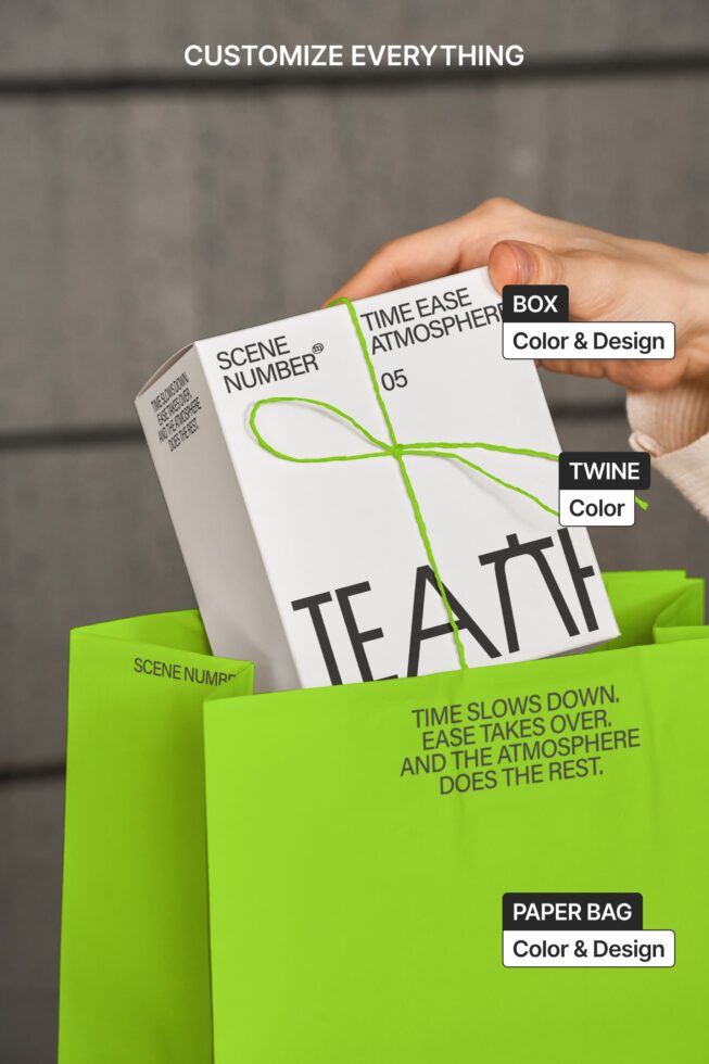 Hand pulling white box from green paper bag with twine, labeled components