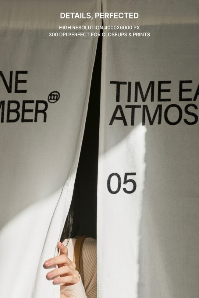 Split curtain panels with partial text visible, person holding fabric gap open