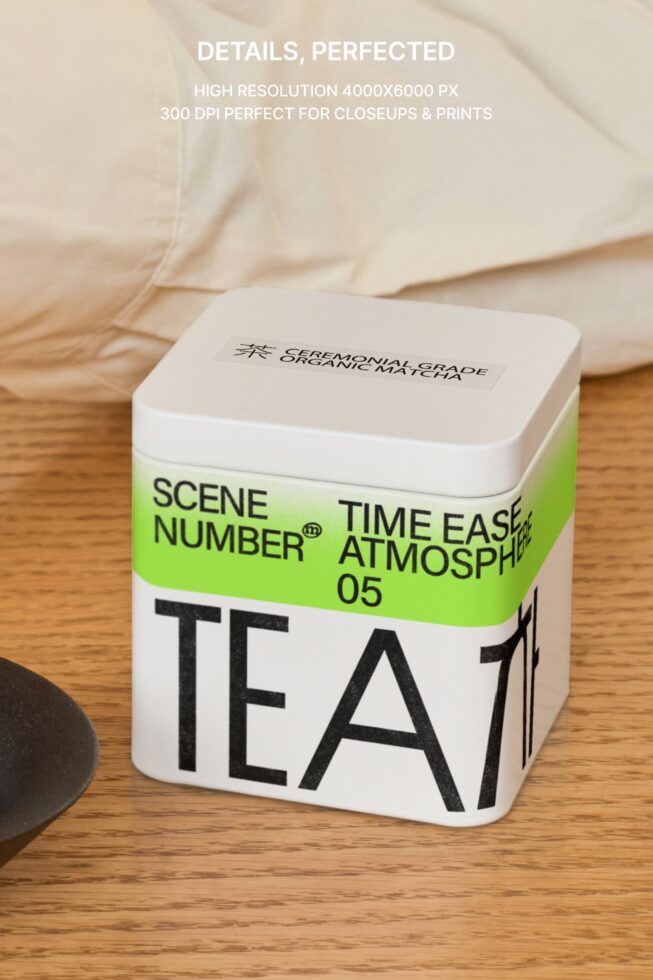 Square white tea box with green band showing product label against wood
