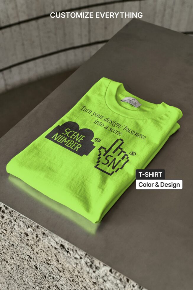 Bright yellow tee lying on concrete surface showing front design with tag visible