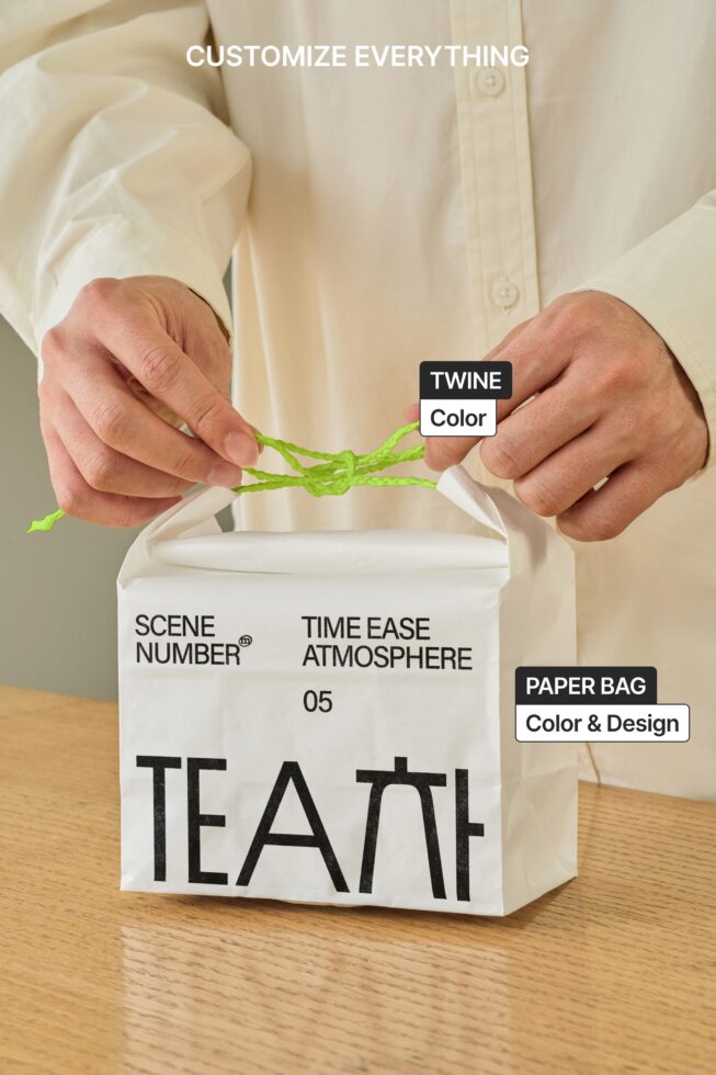 Hands tying bright green twine around white paper bag with black lettering