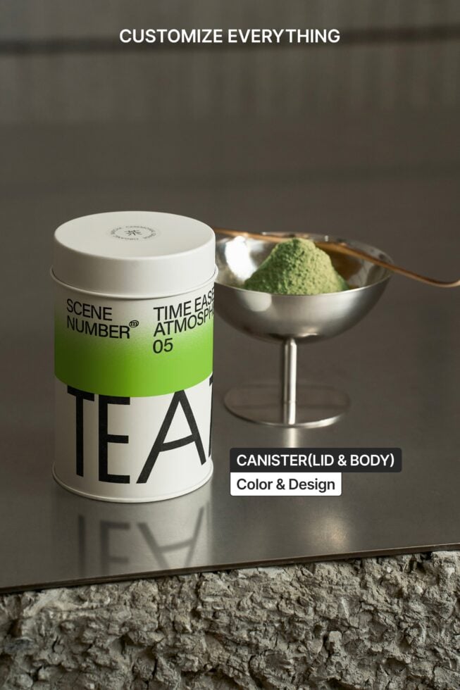 Single tea canister next to silver bowl filled with matcha powder, wooden utensil visible