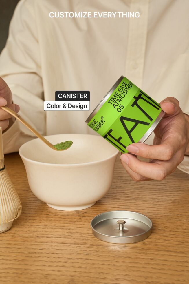 Hand holding bright green canister label over cream ceramic bowl