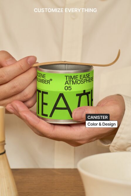 Hands holding bright green tea canister with wooden handles