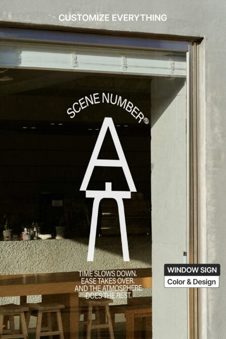 Storefront window with large white letter A blocking view of interior seating