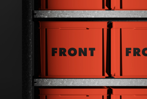 Red metal boxes with black text next to dark industrial column