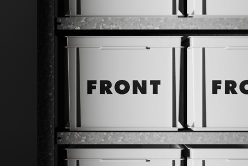 White metal boxes with black text on industrial concrete wall