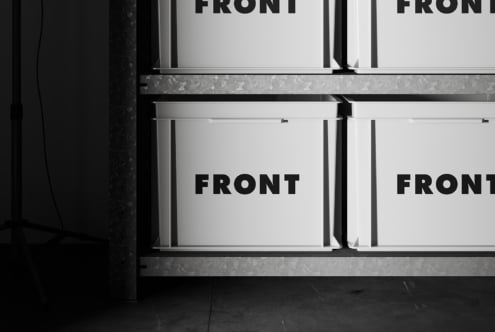 White retail boxes on industrial shelving with editable front panel