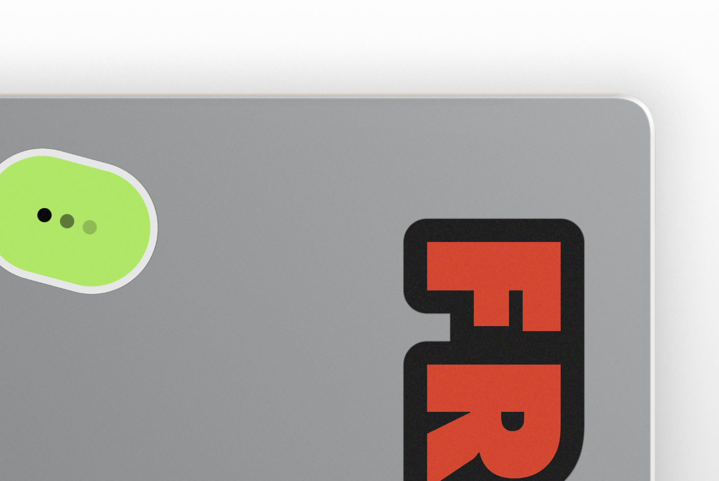 MacBook sticker mockup with lime green chat bubble, typing dots, red logo