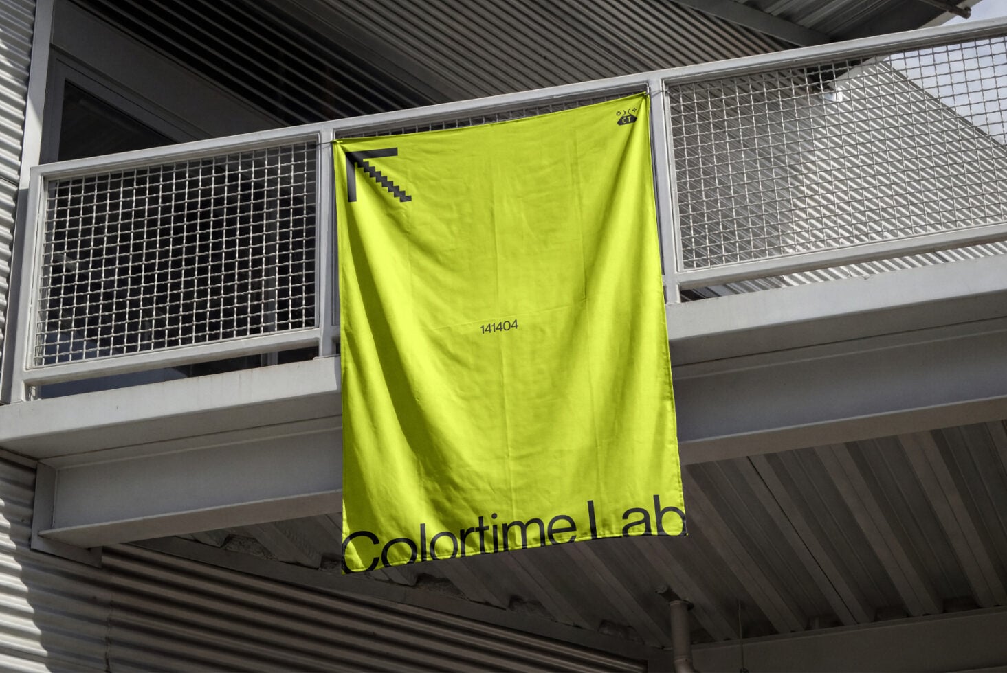 Bright neon yellow banner hanging on industrial railing in warehouse space