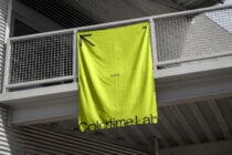 Bright neon yellow banner hanging on industrial railing in warehouse space