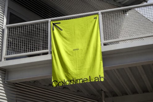 Bright neon yellow banner hanging on industrial railing in warehouse space