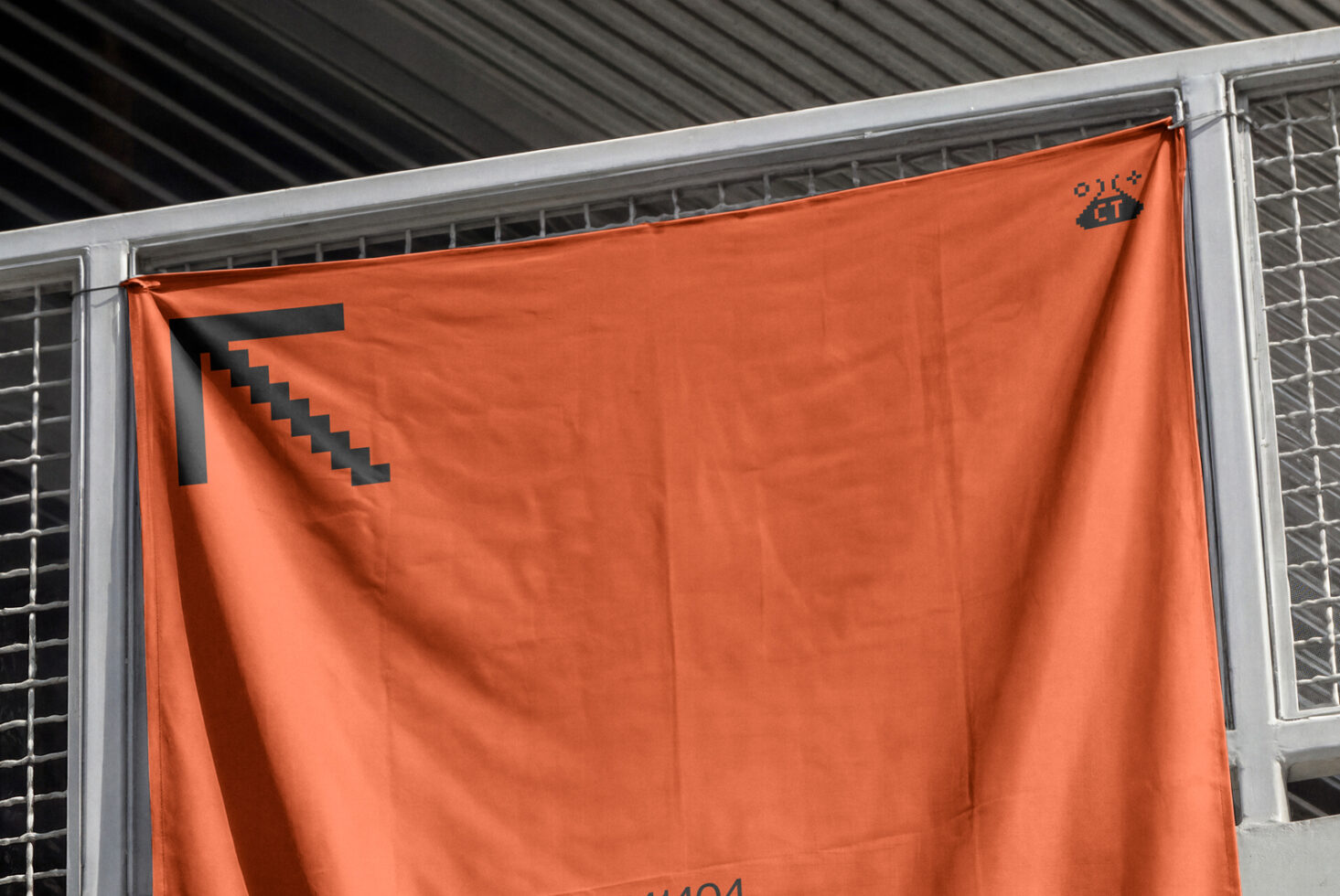 Orange fabric banner with black geometric arrow logo on metal frame