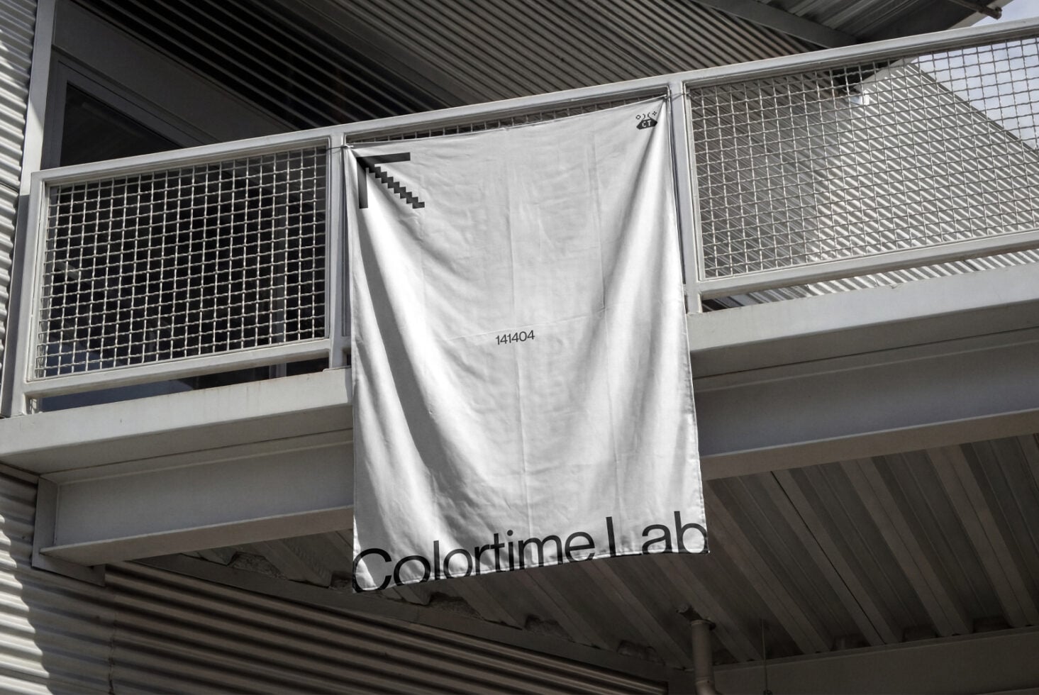 White fabric banner hanging on industrial railing with colortime.lab branding