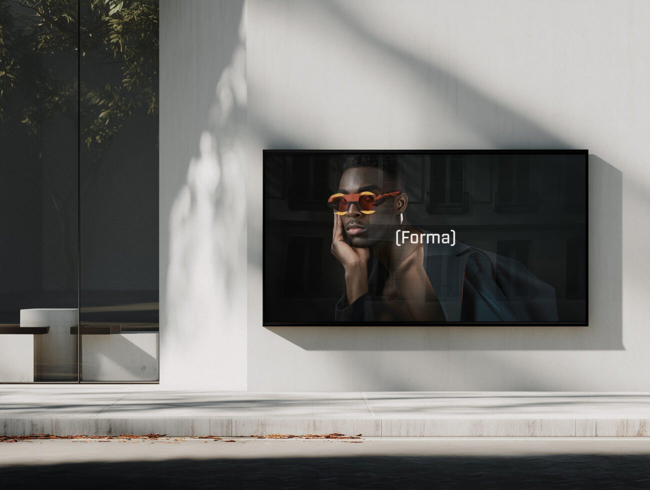 Horizontal screen mockup on white wall showing man in orange sunglasses