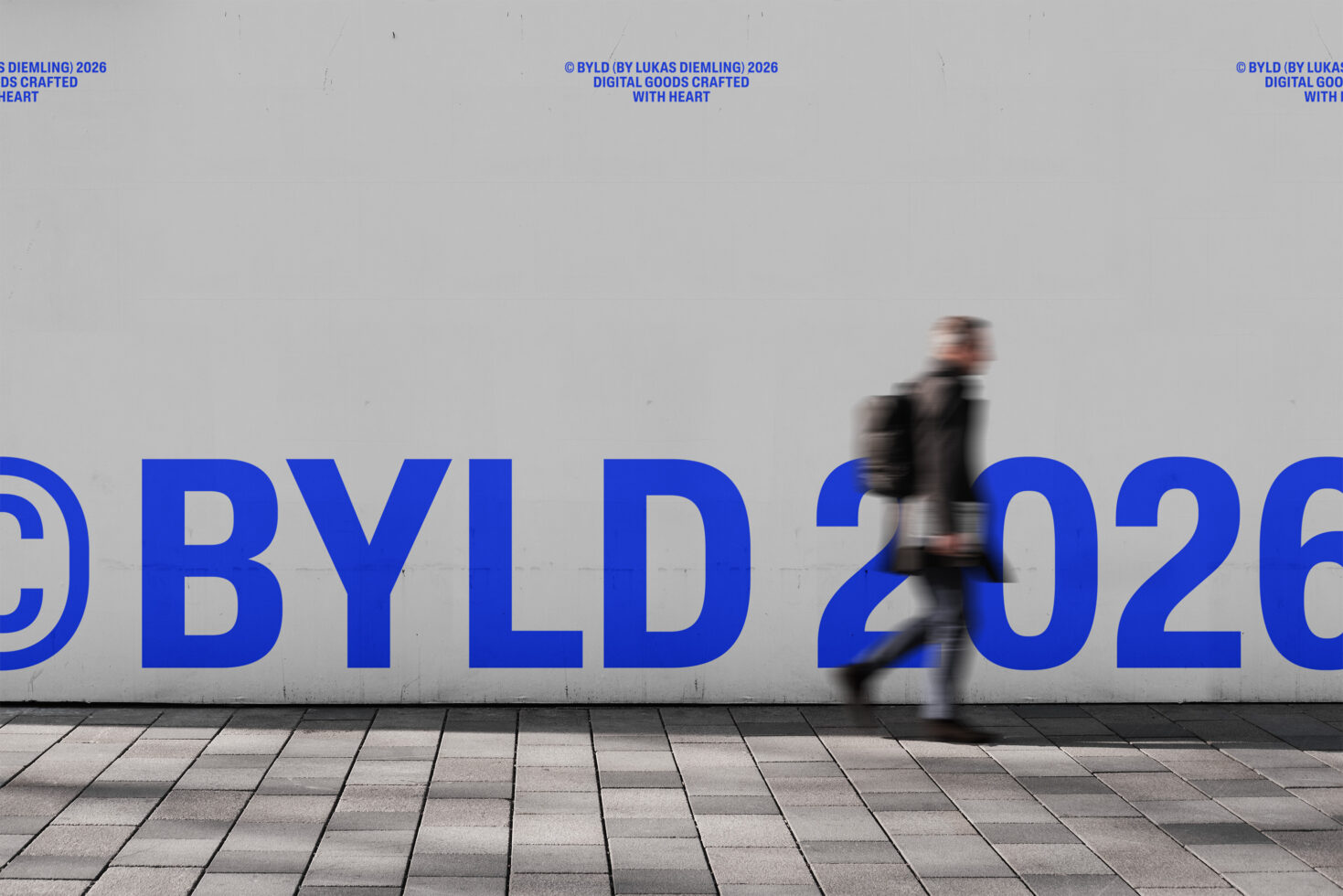 Blurred person walking past large blue BYLD 2026 wall text