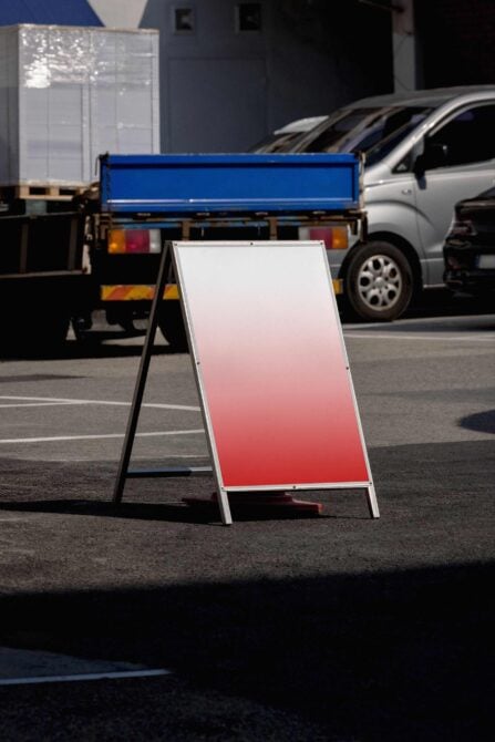 A-frame sign on parking lot showing pink to white gradient mockup surface