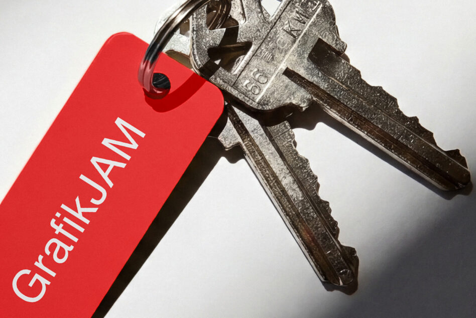 Red key tag with GrafikJAM text attached to two old metal keys