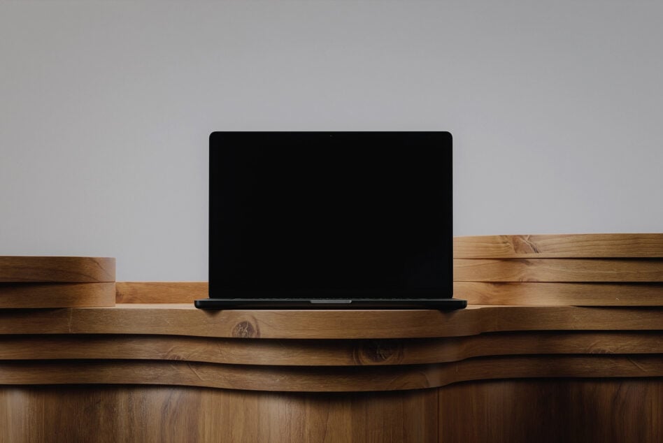Laptop mockup on curved wooden shelf with blank black screen display
