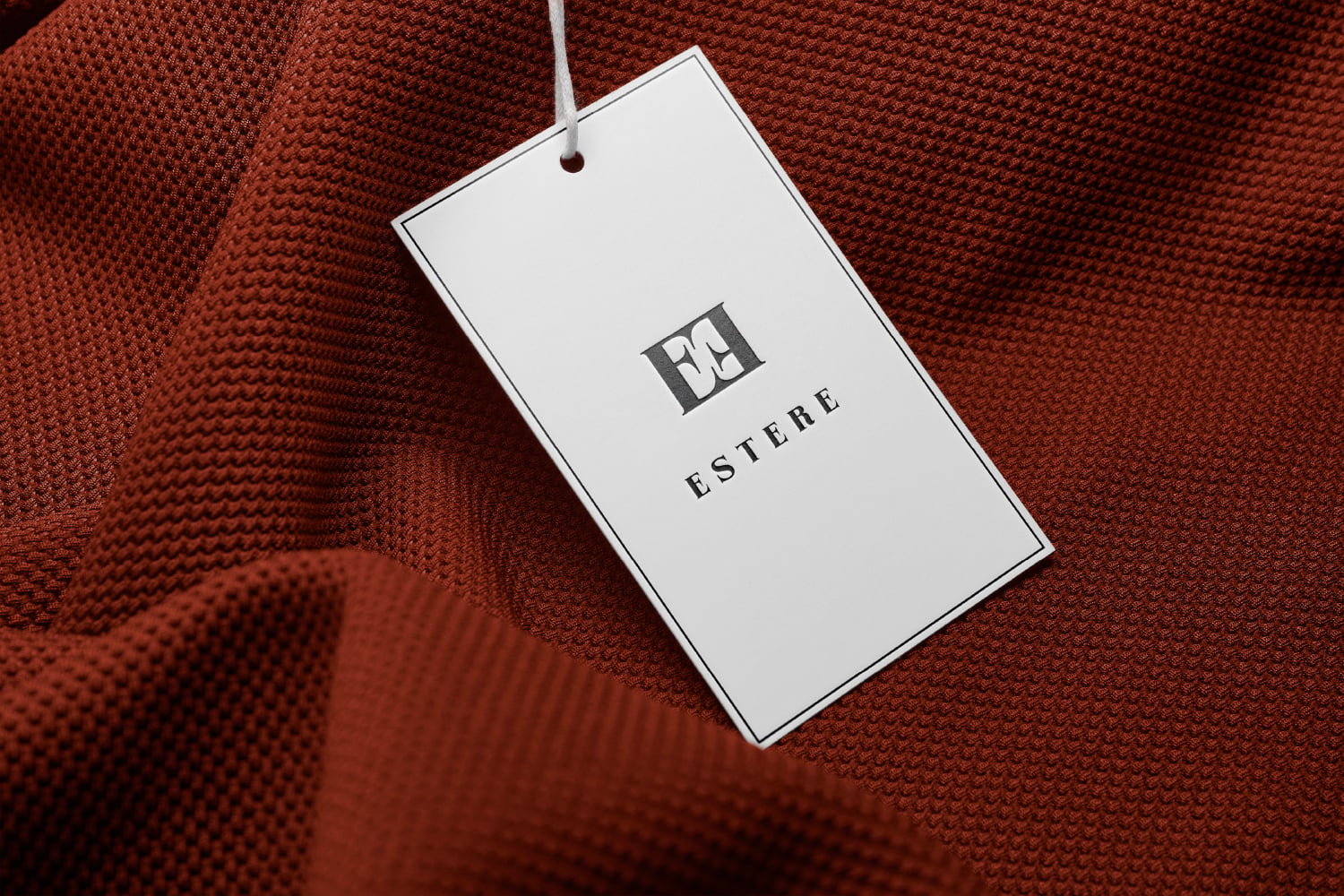 Estere fashion label tag hanging on terracotta knit fabric