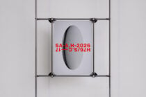 Metal clamp frame with oval cutout displaying red text on poster