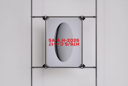 Metal clamp frame with oval cutout displaying red text on poster
