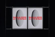 Metal clamp frame displaying two red text posters against dark backdrop