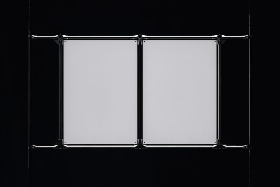 Industrial metal clamps suspending dual blank posters on black background