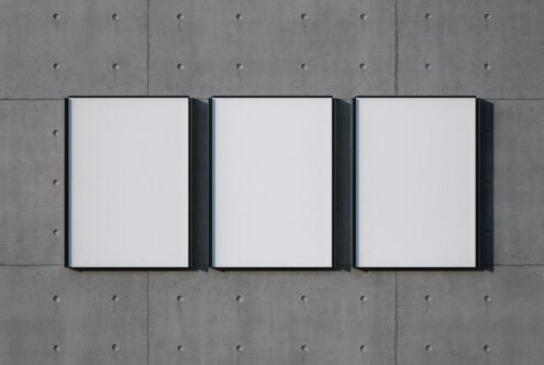Three black-framed canvas mockups on concrete wall with rivet details