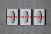 Three framed prints showing 3D spheres with red text overlay on concrete
