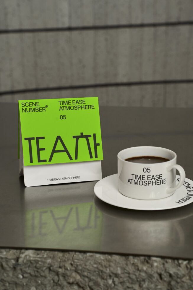 Lime green tea box mockup positioned beside white coffee mug on table