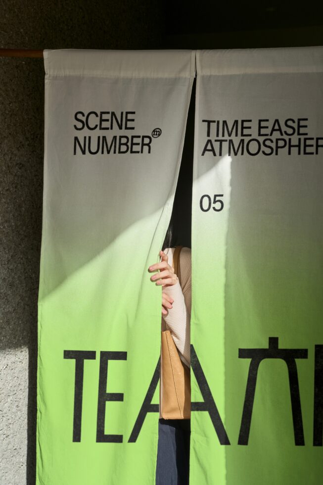 Two oversized cream fabric banners with green gradient showing large black text typography