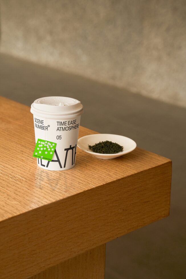 White canister with cap on wooden block beside small ceramic dish of herbs