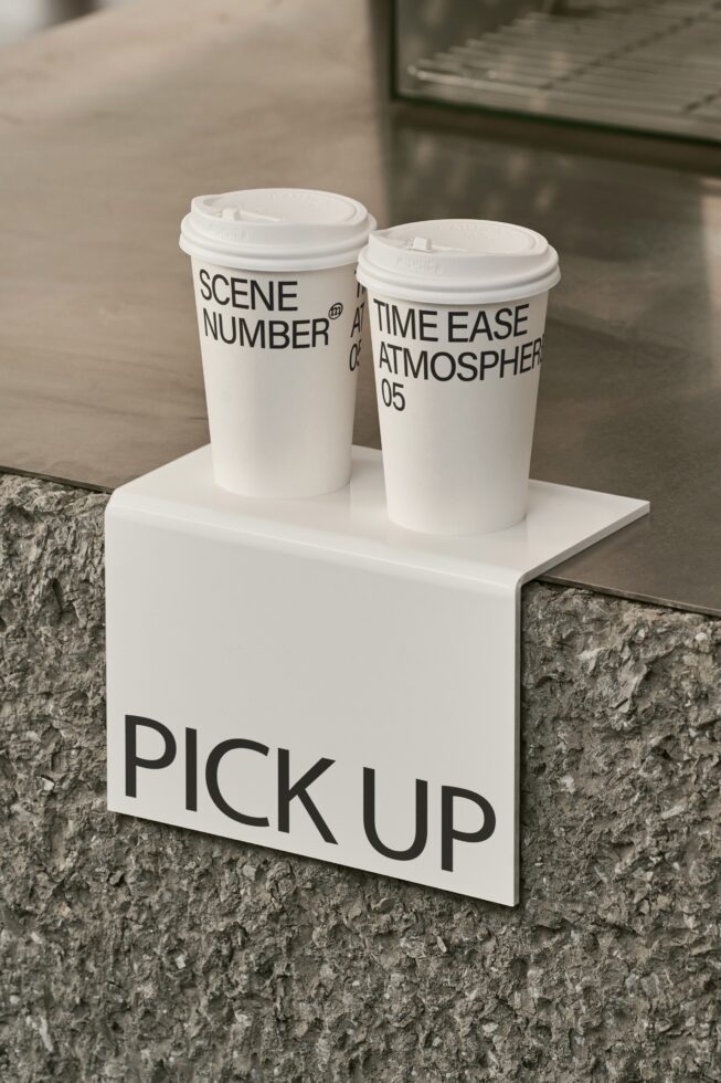 White coffee cups with Scene Number text on white pedestal near concrete