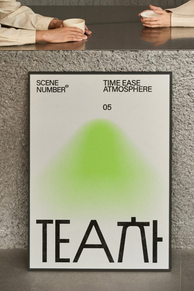 Hands holding cups beside framed poster with green gradient design centered