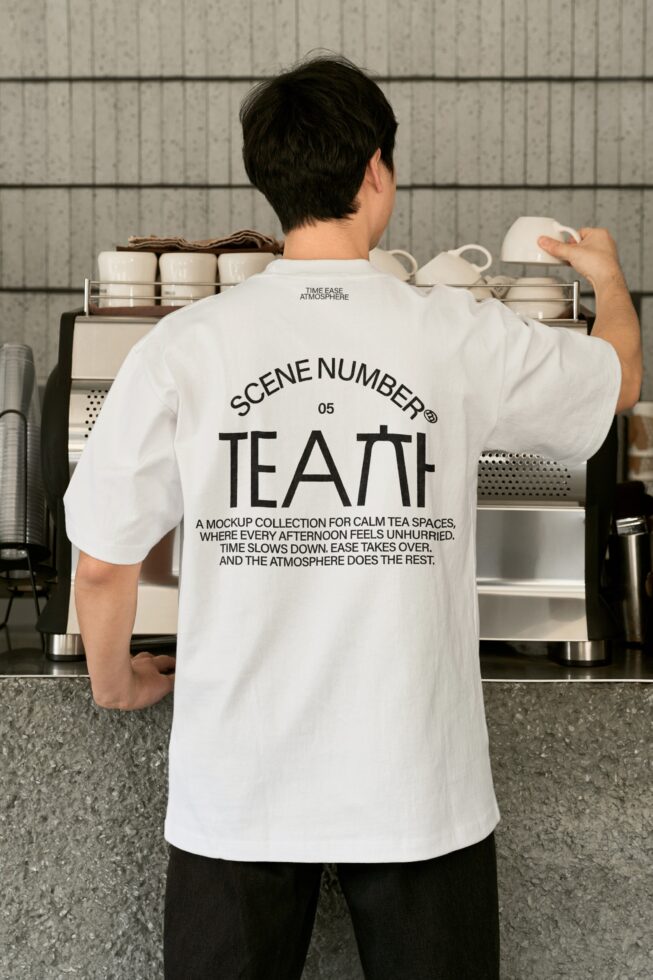 Guy in white shirt reaching for cups in minimalist tea shop setup