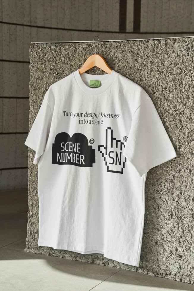White oversized tee on wooden hanger against industrial concrete wall