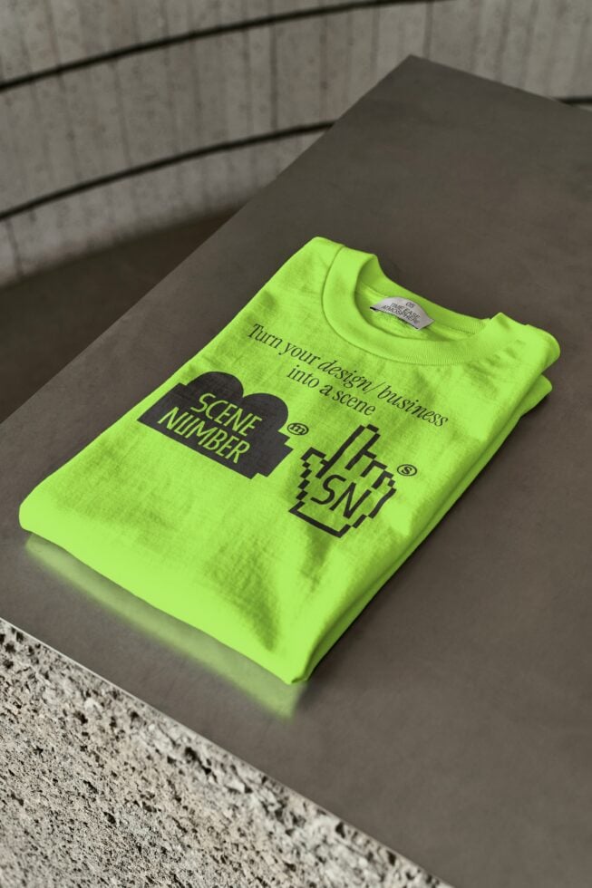 Neon yellow tee folded on concrete with black graphic design mockup
