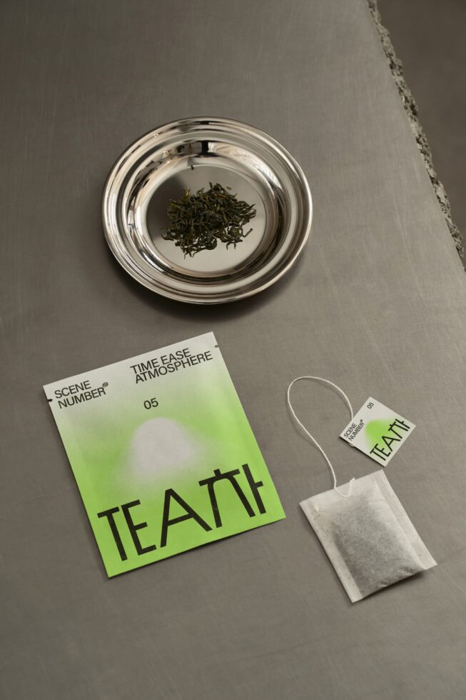 Tea branding mockup flat lay with glass bowl, tea bag, neon green gradient label