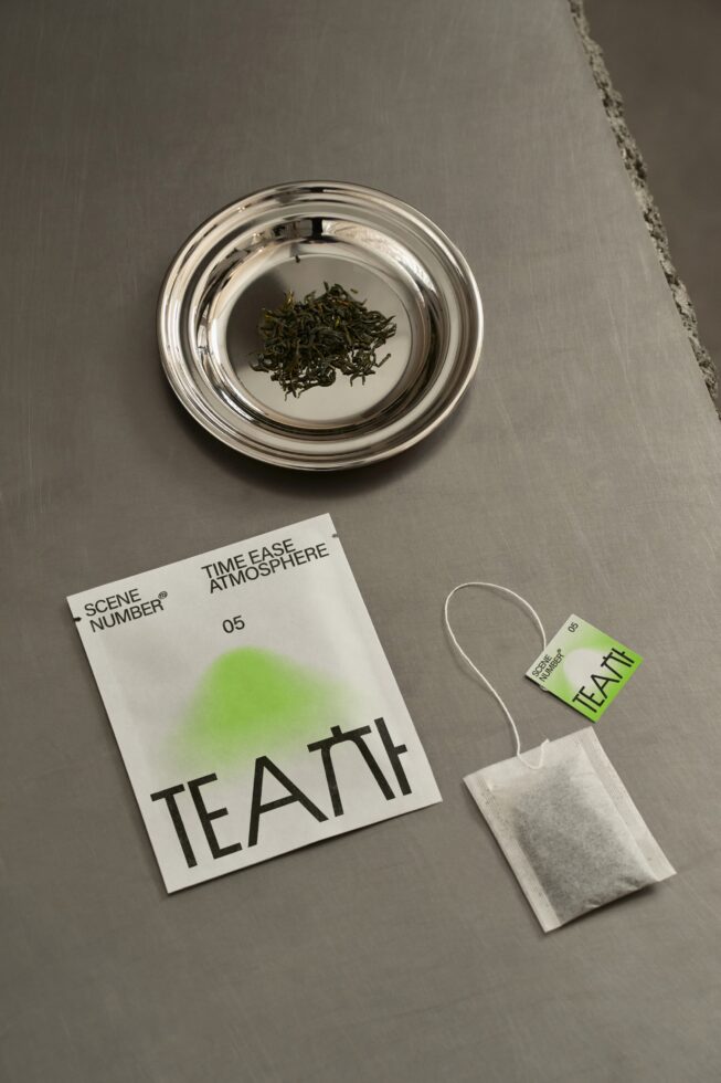Overhead shot of tea packaging mockup with glass bowl, tea bag, green gradient design