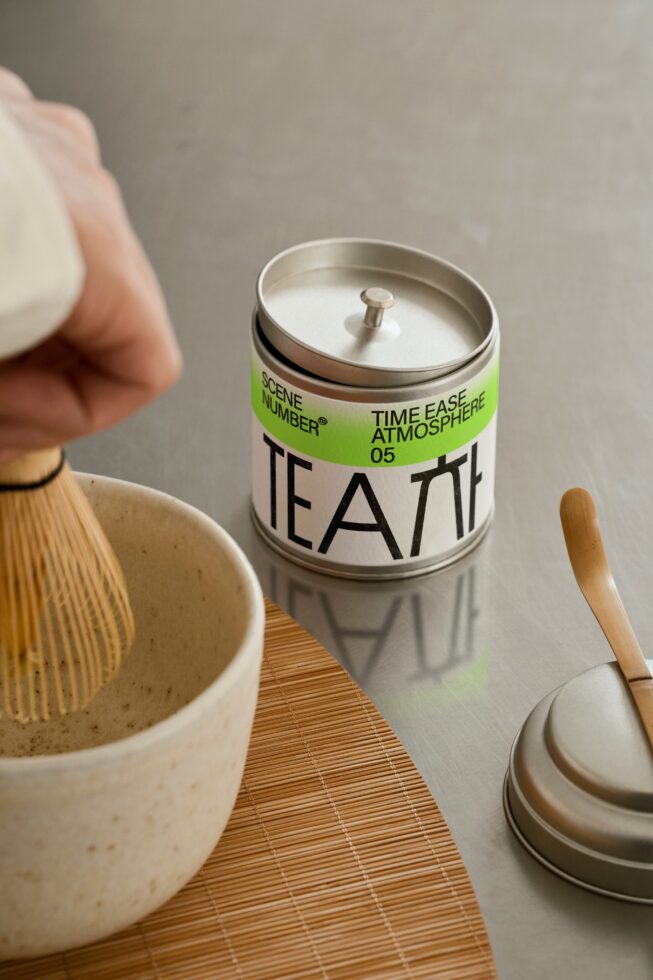 Overhead shot of white tea tin with bright green label, ceramic bowl visible