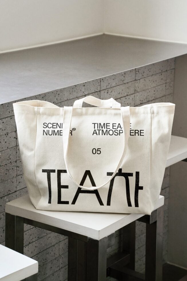 Large cream tote bag sitting on concrete shelf with black tea print