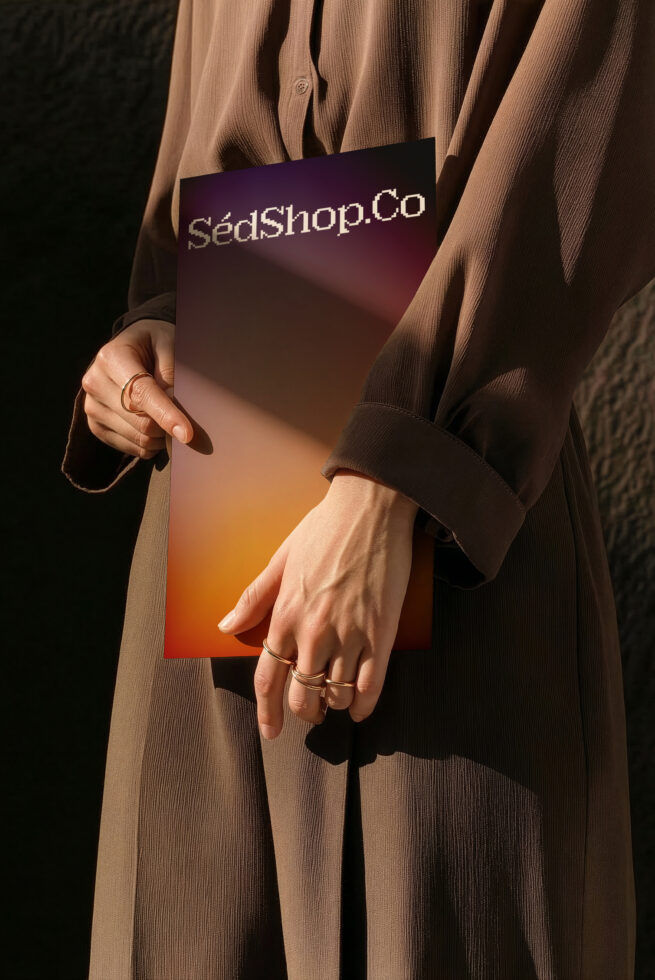 Styled shot of burgundy to orange gradient card in hands with jewelry