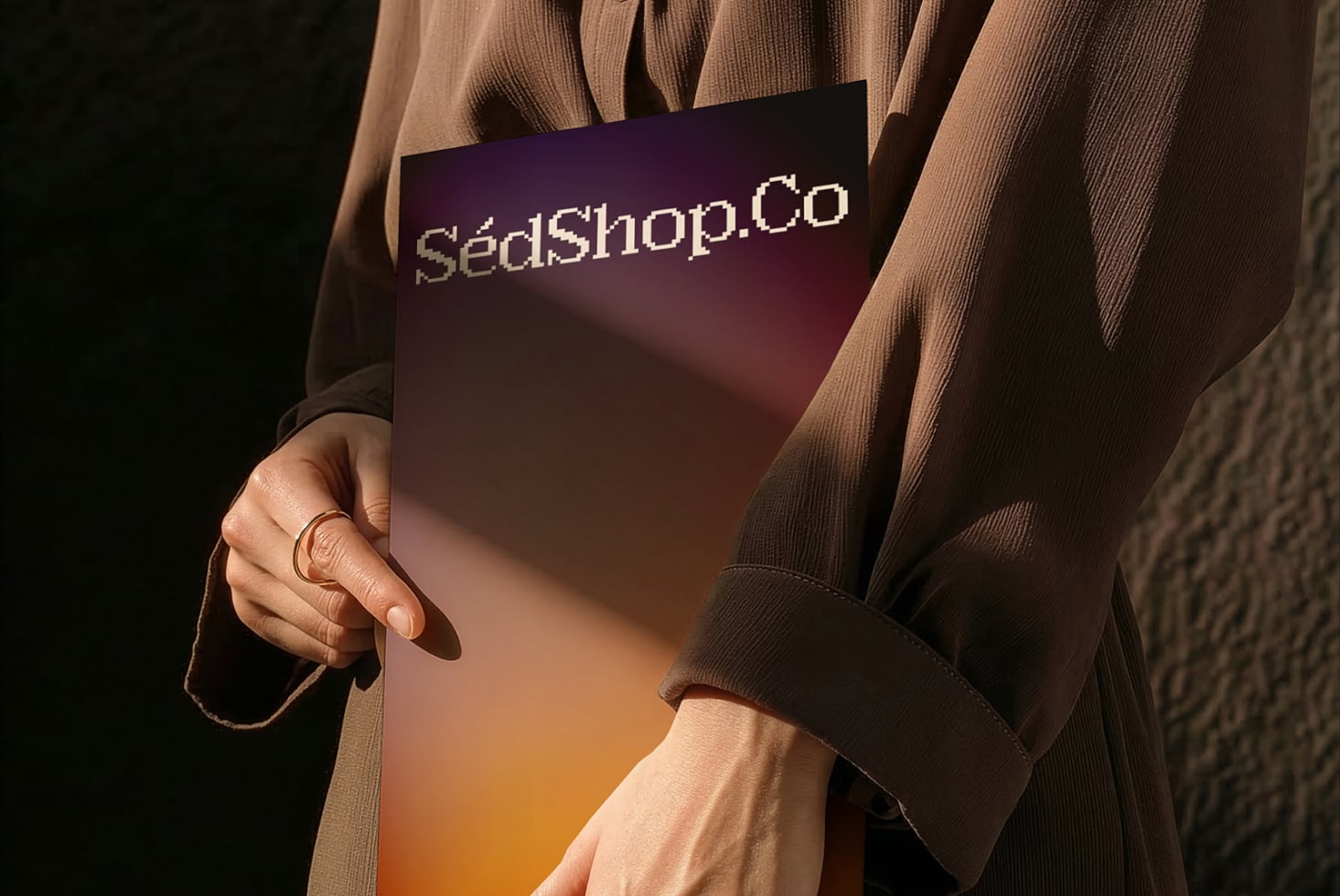 Deep purple fading to warm tones card held in hands with rings