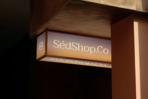 Illuminated storefront sign reading SeckShop.Co mounted on wooden storefront
