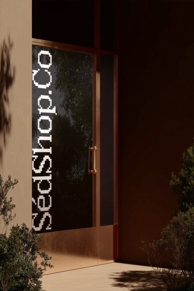 Dark storefront door with vertical white pixelated SedShop.Co text running down glass