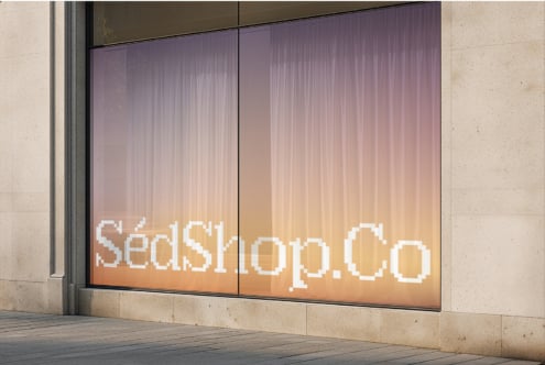 Storefront window with warm gradient background, white serif text, modern facade display