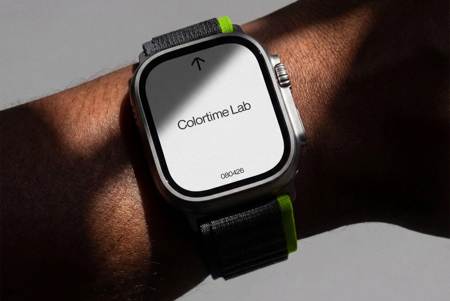Smartwatch on wrist with bright neon band showing light colored screen