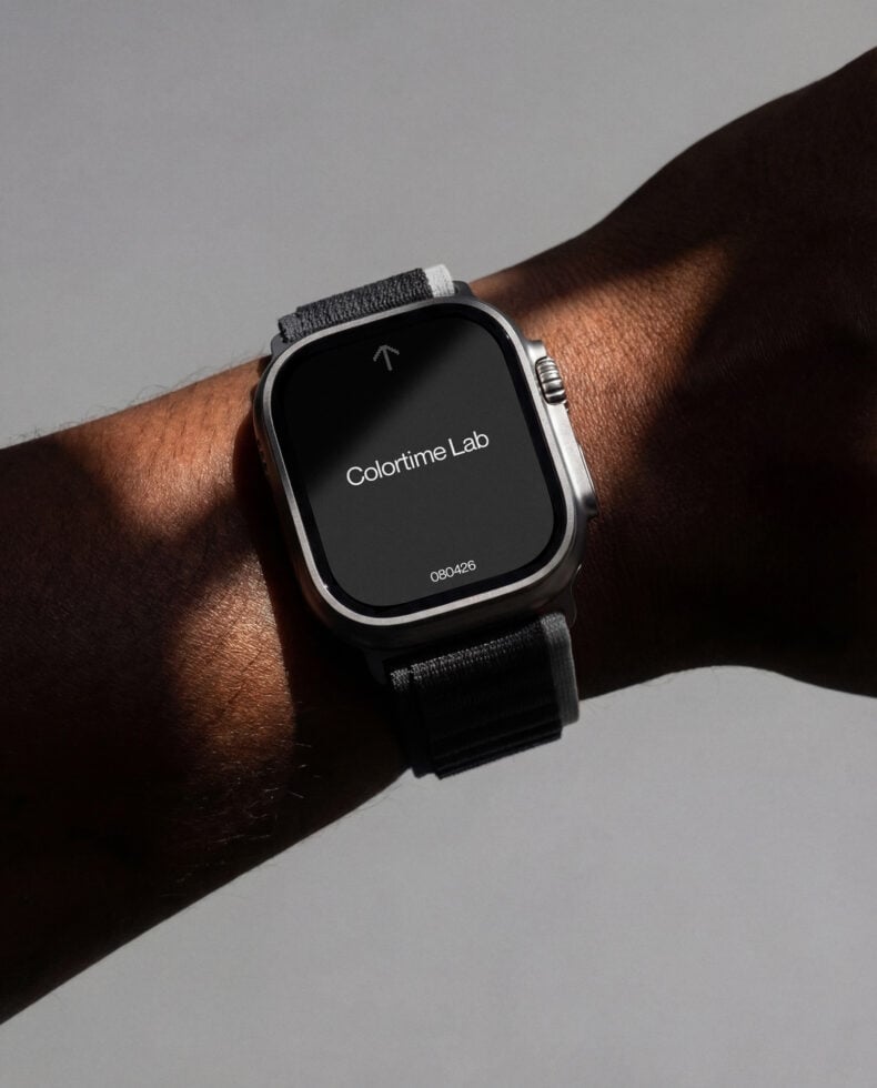 Smartwatch on wrist with dark fabric band showing app screen