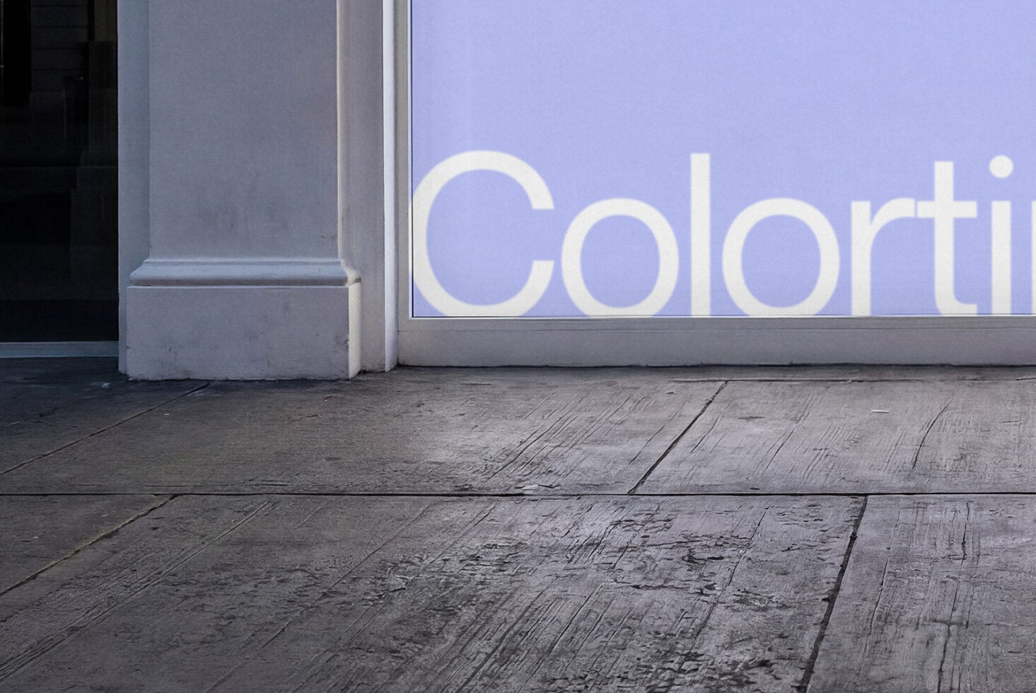 Storefront window with cream letter text reading Colorti on periwinkle background